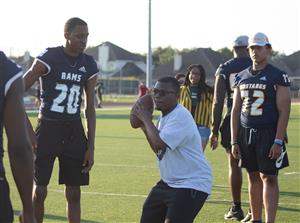 Cypress Ridge and Cypress Ranch football players oversee a passing drill at Camp Courage.